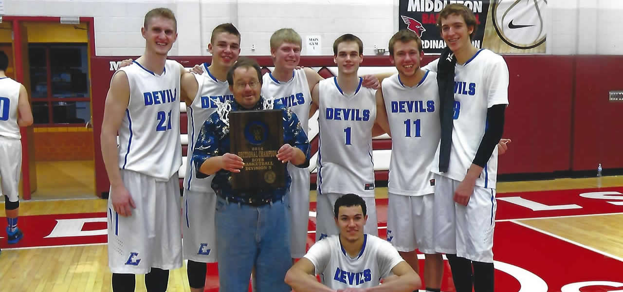 Dano with a basketball net on his shoulders, holding a Lodi regional championship plaque